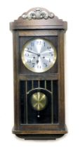 An early 20thC oak cased drop dial wall clock, circular silvered dial bearing Arabic numerals, eight