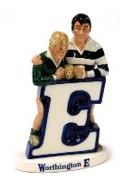 A Beswick Worthington E pottery advertising figure group, featuring two rugby players resting agains