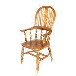 A 19thC oak and elm Windsor chair, with a carved splat, scrolling arms, raised on spindles, solid sa