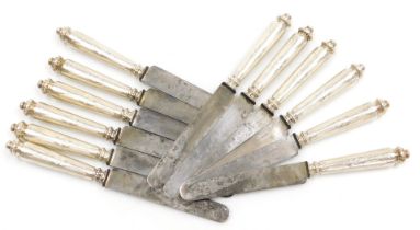 A set of twelve late 19thC French table knives, with white metal handles, having engine turned and e