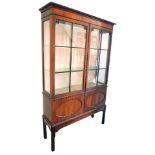 A Victorian mahogany display cabinet, the outswept pediment over a pair of astragal glazed doors, en