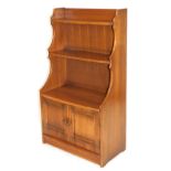 An Ercol elm waterfall bookcase, above a pair of panelled doors, raised on a plinth base, 113cm high