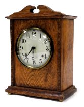 An Edwardian oak cased mantel clock, circular enamel dial bearing Arabic numerals, eight day America