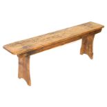 A Victorian pine bench, raised on trestle end supports, 45cm high, 141cm wide.