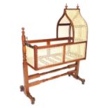 A Victorian mahogany and wicker cradle, raised on a turned stand united by turned stretchers, 128.5c