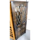 A dark oak corner display cupboard, with leaded glazed doors over two panelled doors. Lots 1501 to