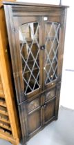 A dark oak corner display cupboard, with leaded glazed doors over two panelled doors. Lots 1501 to