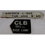 A painted wooden road sign, bearing painted metal letters for America Lodge Through Road, some lette