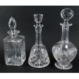 Three cut glass decanters, comprising a square decanter and stopper, 28cm high, a mallet shaped deca