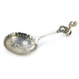 A Continental white metal caddy spoon, the bowl with a hammered edge and impressed beaded banding, d