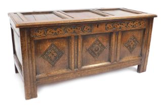 An 18thC oak coffer, with three panelled top above three panelled carved sections, terminating