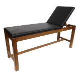 A beech framed massage couch, with black leatherette top, 77cm high, 180cm wide, 60cm deep.