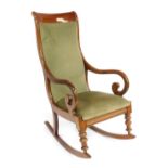 An Edwardian mahogany rocking chair, with shaped supports, on green cushioned seat.