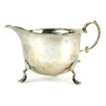 An Edward VII silver cream jug, with shaped rim, raised on three hoof supports, Birmingham 1903, 2.9