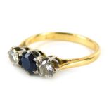 An 18ct gold sapphire and diamond three stone dress ring, the central round brilliant cut sapphire i