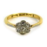 A diamond floral cluster ring, set with round brilliant cut diamond formed as a cluster in a rub ove