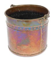 A copper coal bucket, of cylindrical form, with ring handle, decorated with a band of raised roundel