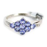 A tanzanite and diamond dress ring, central cluster design with tanzanite marker and tiny diamond se