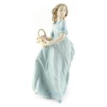 A Lladro porcelain figure, modelled as a lady holding flower basket, printed marks, 22cm high.