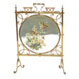 A brass Arts and Crafts fire screen, of rectangular shape with a central mirrored panel, hand painte