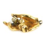A charm in the form of a hand holding a pair of dice, yellow metal, stamped 14K, 11.2g.