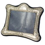 An Elizabeth II silver photograph frame, of shaped rectangular form, embossed with gadrooned border,