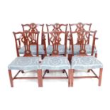 A set of six mahogany dining chairs in George III style, each with a shaped leaf carved rail, open s
