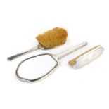 A George VI silver mounted dressing table set, comprising hand mirror, hair brush and clothes brush,