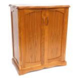 A modern walnut finish cupboard, with serpertine top above arrangement of two doors, with moulded h