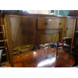 A mahogany serpentine fronted sideboard in George III style, the top with a moulded edge, the base w