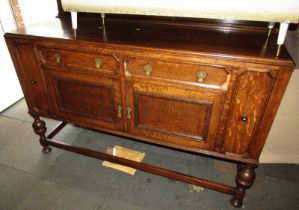 An early 20thC oak sideboard, the top with a raised back, the base with two drawers above two cupboa