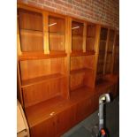 A G-Plan wall unit, the top with two pairs of glazed doors above a recess, the base with four cupboa