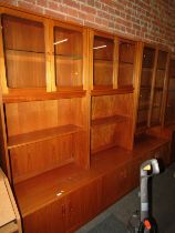 A G-Plan wall unit, the top with two pairs of glazed doors above a recess, the base with four cupboa