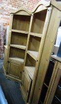 A pair of pine standing corner cabinets, with three shelves above a cupboard base, 180cm high, 71cm