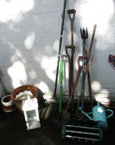 A group of garden tools, to include spade, rake, watering can, terracotta plant pot and other pots,