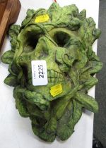 A green man hanging skull wall mask.