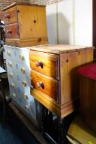 A group of furniture, comprising an oak nest of three tables, two pine two drawer bedside tables, co