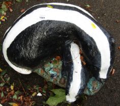 A painted composition garden ornament, modelled as two badgers, 50cm wide.