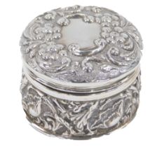 An Edward VII silver dressing table jar, with hammered floral decoration, with daisies and tulips, B