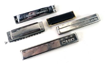 A group of harmonicas, comprising a Suzuki Winner harmonica, a Hohner Echo, slide hard Hohner, and o