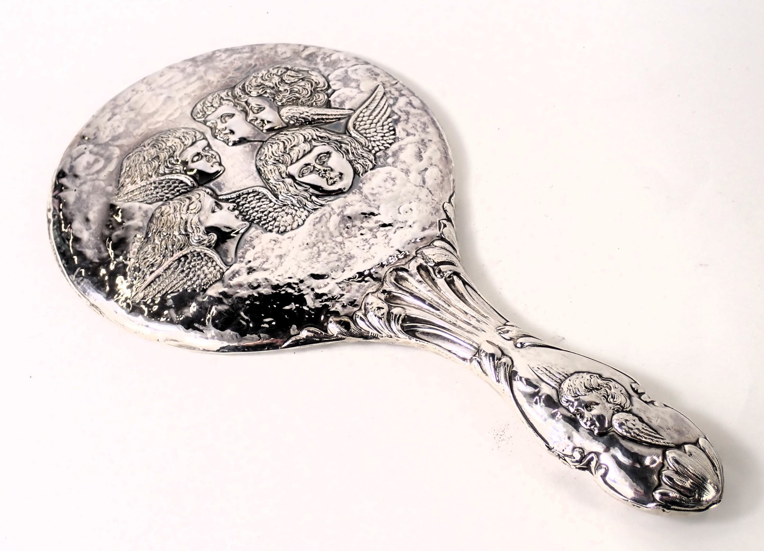 A George V silver backed dressing table mirror, with embossed children with wings, and scroll handle - Image 2 of 3