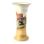 A Royal Worcester porcelain wasted cylindrical vase, painted with a cottage within landscape, signed