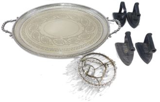 A late Victorian oval engraved two handled tray, with pierced border, four various flat irons, and a