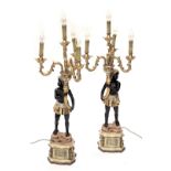 A pair of painted resin blackamoor figural table lamps, each carrying a cornucopia, with four scroll