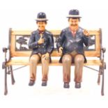 Two painted composition figures of Laurel and Hardy, 63cm high, and a stained pine bench, with Noah'