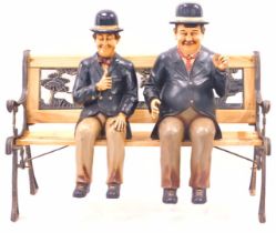 Two painted composition figures of Laurel and Hardy, 63cm high, and a stained pine bench, with Noah'