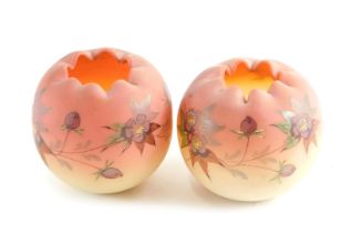 A pair of Victorian pink and cream opaque globular glass vases, each decorated with flowers in raise