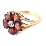 A 9ct gold cluster ring, the outer petals set with dark red heart shaped stones and a central CZ sto