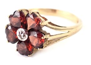 A 9ct gold cluster ring, the outer petals set with dark red heart shaped stones and a central CZ sto