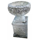 A reconstituted stone garden urn, on a square foot with wreaths, 73cm high, 41cm wide.